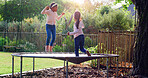 Trampoline, jumping and children in backyard for fun, playing and bonding together on weekend. Happy, development and girl kids on bouncing playground for connection, growth or care in garden.