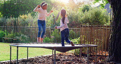 Buy stock photo Trampoline, jumping and children in backyard for fun, playing and bonding together on weekend. Happy, development and girl kids on bouncing playground for connection, growth or care in garden.