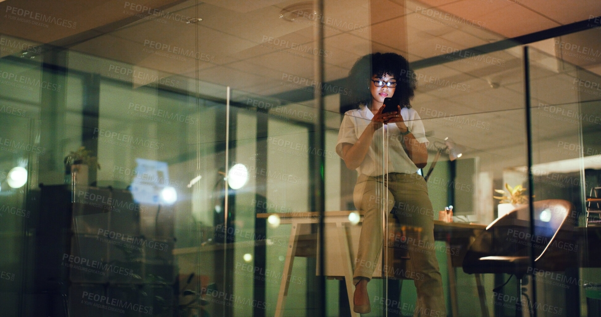 Buy stock photo Woman, phone and night at startup, texting or glasses with deadline for social media marketing. Person, smartphone and low angle with mobile app, contact or check notification with overtime at agency