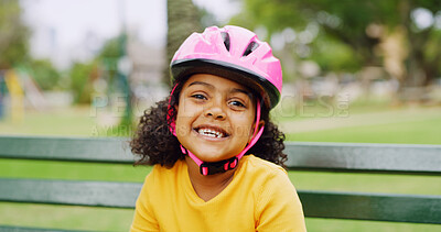 Buy stock photo Helmet, portrait and smile of girl child on park bench for activity, hobby or responsibility. Protection, safety and youth with excited kid outdoor in nature for development, learning or motor skills