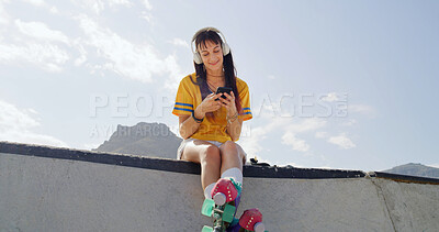 Buy stock photo Woman, roller skates and phone at park with headphones, smile and listen to music with space in city. Person, skater and smartphone with streaming subscription, audio and relax on ramp in urban town