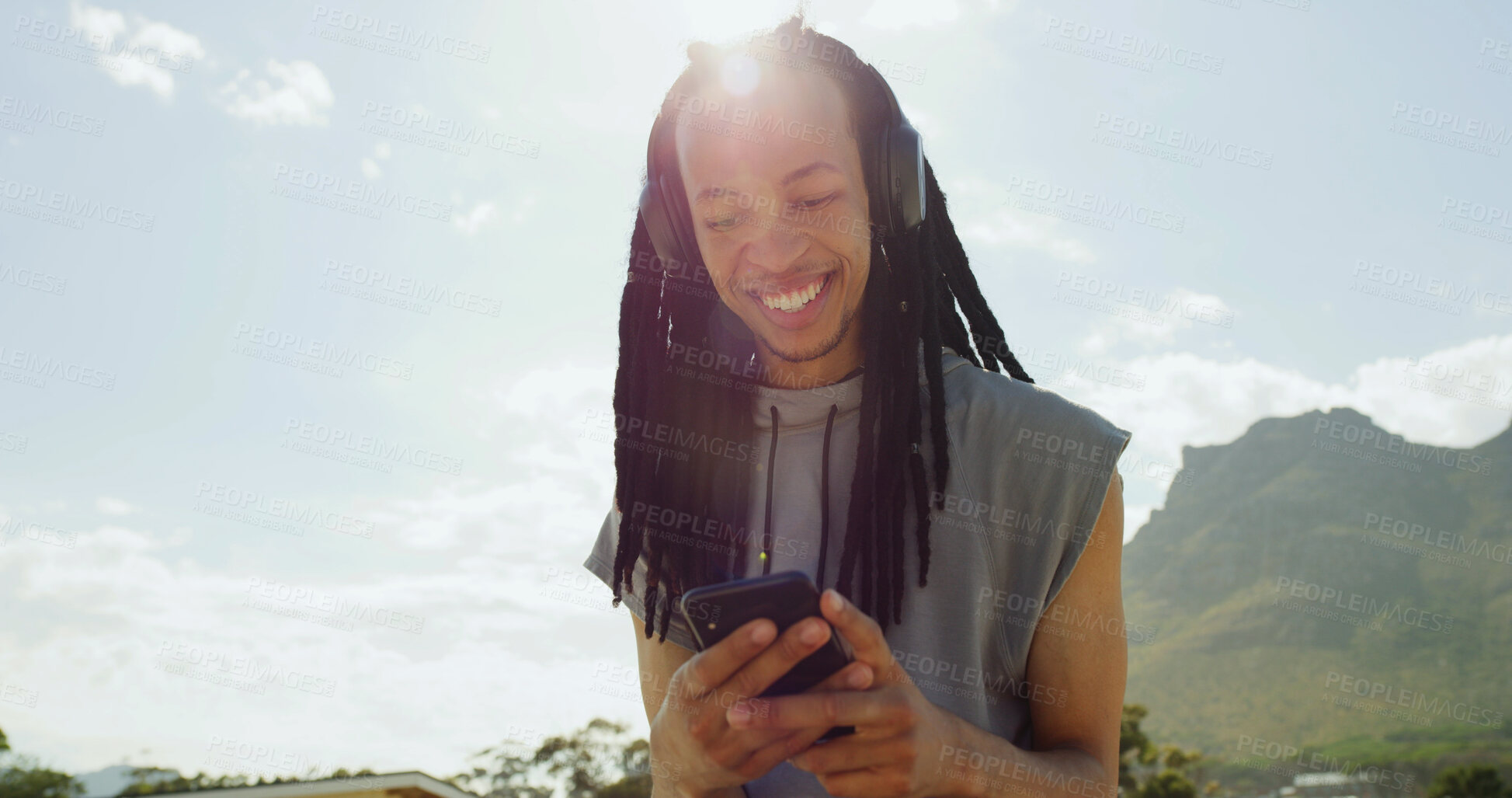 Buy stock photo Black man, headphones and happy with phone outdoor, streaming and listen to music with space. Person, smartphone and smile with audio subscription, sky or scroll for song on mobile app in summer