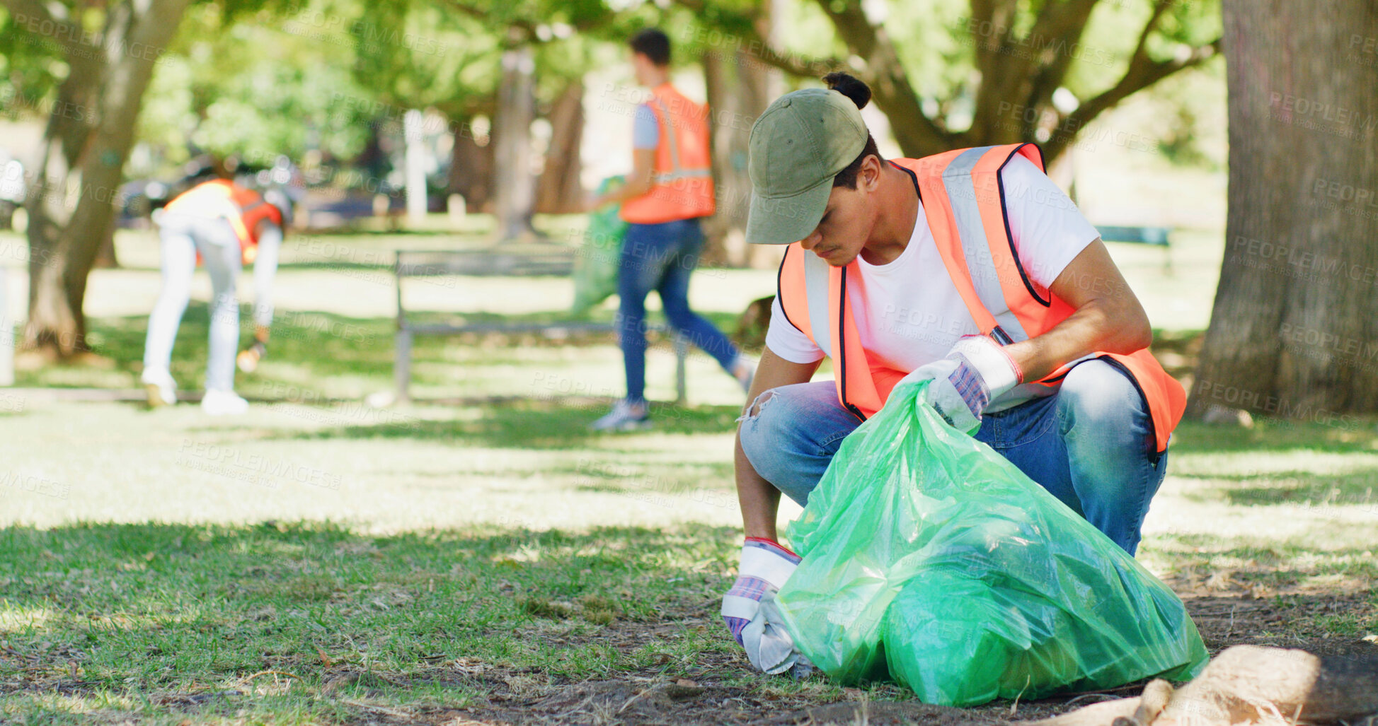 Buy stock photo Volunteer, cleaning and man in park with plastic bag to collect trash, garbage and litter for pollution. Outdoor, earth day and person in nature for community service, recycling and environment