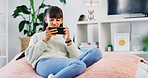 House, smartphone gaming and teenage girl on sofa, relax and video streaming in living room. Social media, player and child on couch, cellphone and digital app for online score, internet and network
