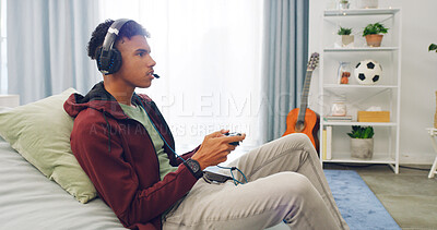 Buy stock photo Couch, esport and teenager playing video game with controller in living room for online challenge in home. Gamer, headphones and male person for streaming, entertainment or virtual competition