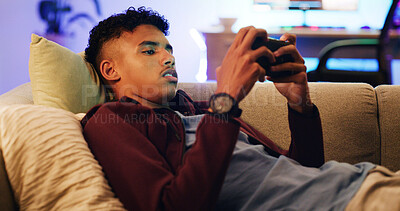 Buy stock photo Relax, cellphone gaming and teenage boy on sofa, typing and video streaming in living room. Home, contest and player on couch, smartphone and digital app for online score, internet and entertainment