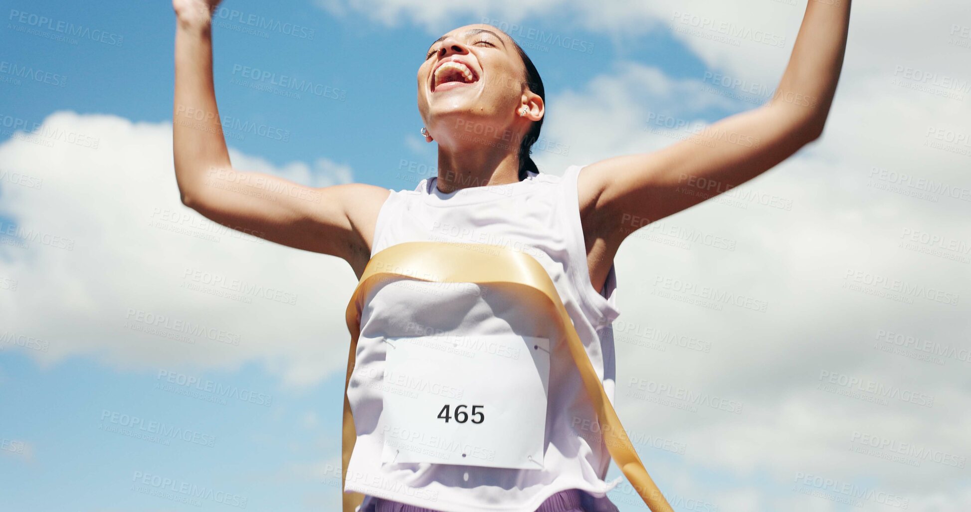 Buy stock photo Woman, marathon and celebration with ribbon at finish line with low angle, goals and winning performance. Person, champion and happy runner with achievement, success and shout for sports milestone