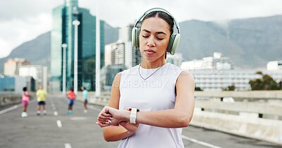 Buy stock photo Headphones, smart watch and woman in city for exercise, marathon training and tracking workout. Sports, athlete and person with tech for wellness, health stats and music for fitness in urban town
