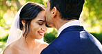 Wedding, happy couple and love in garden with kiss, support and celebration for bridal union or marriage. Bride, groom and people in park with trust for life partner, commitment or together outdoor