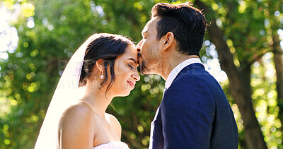 Buy stock photo Wedding, couple and love in park with kiss, support and celebration for bridal union or marriage. Happy bride, groom and people in garden with trust for life partner, commitment or together outdoor