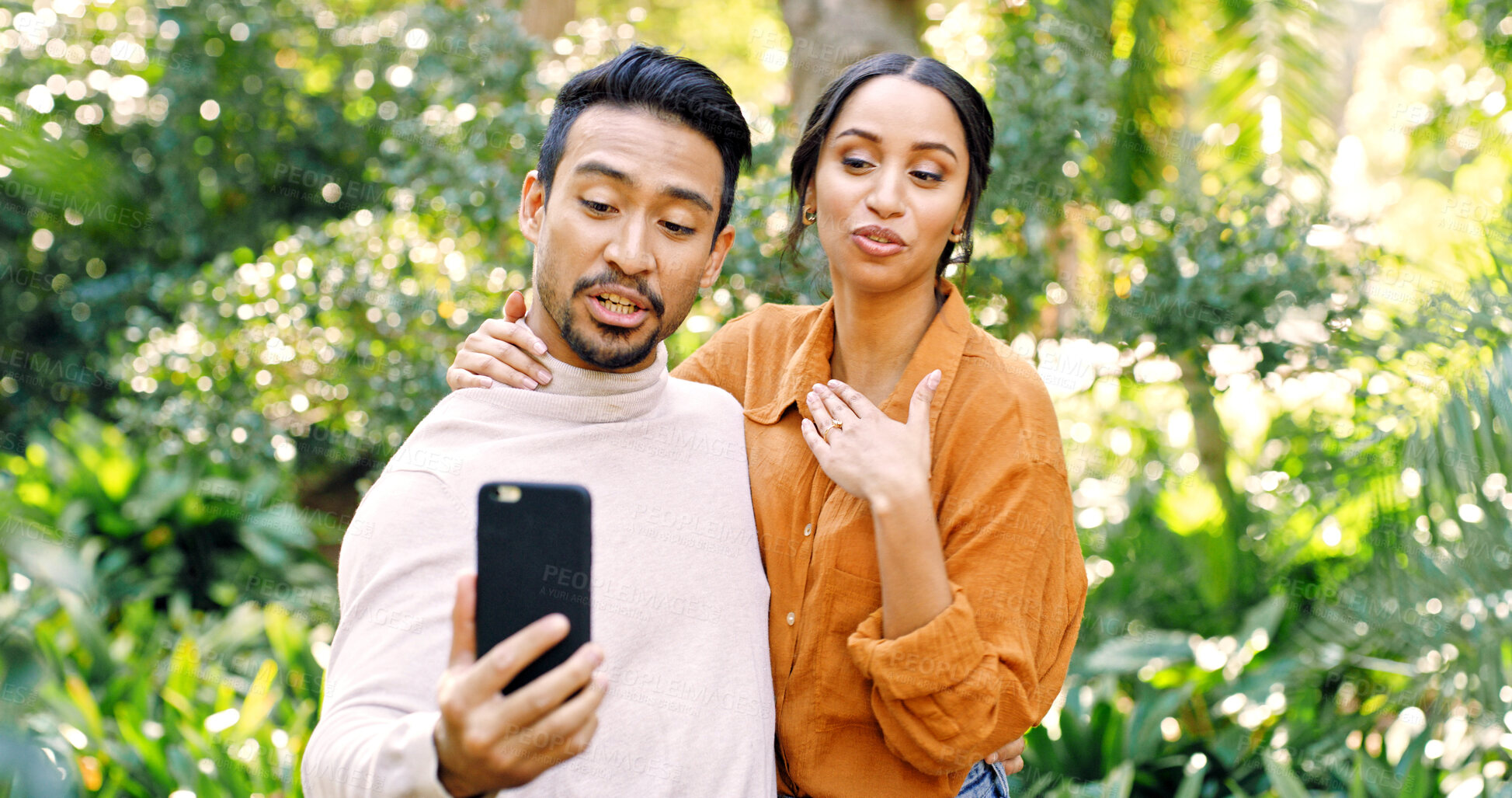 Buy stock photo Couple, phone and video call with talk at park, hello and virtual chat on mobile app in summer. People, partner and smartphone with discussion on social media, contact or smile in nature for bonding