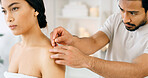 Therapist, woman and shoulder in spa with acupuncture, stress relief and traditional Chinese medicine. Expert, person and wellness at retreat with needle, ancient healing method and pain management.