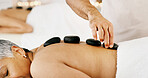 Senior woman, relax and hands with hot rocks for massage, healing or physical therapy in beauty spa. Elderly, female person or stones with masseuse for stress relief or muscle tension in resort