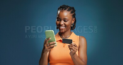 Buy stock photo Happy, black woman and credit card with phone in studio for online shopping on a blue background. Female person, shopper or user with mobile smartphone or debit for banking app or ecommerce on space