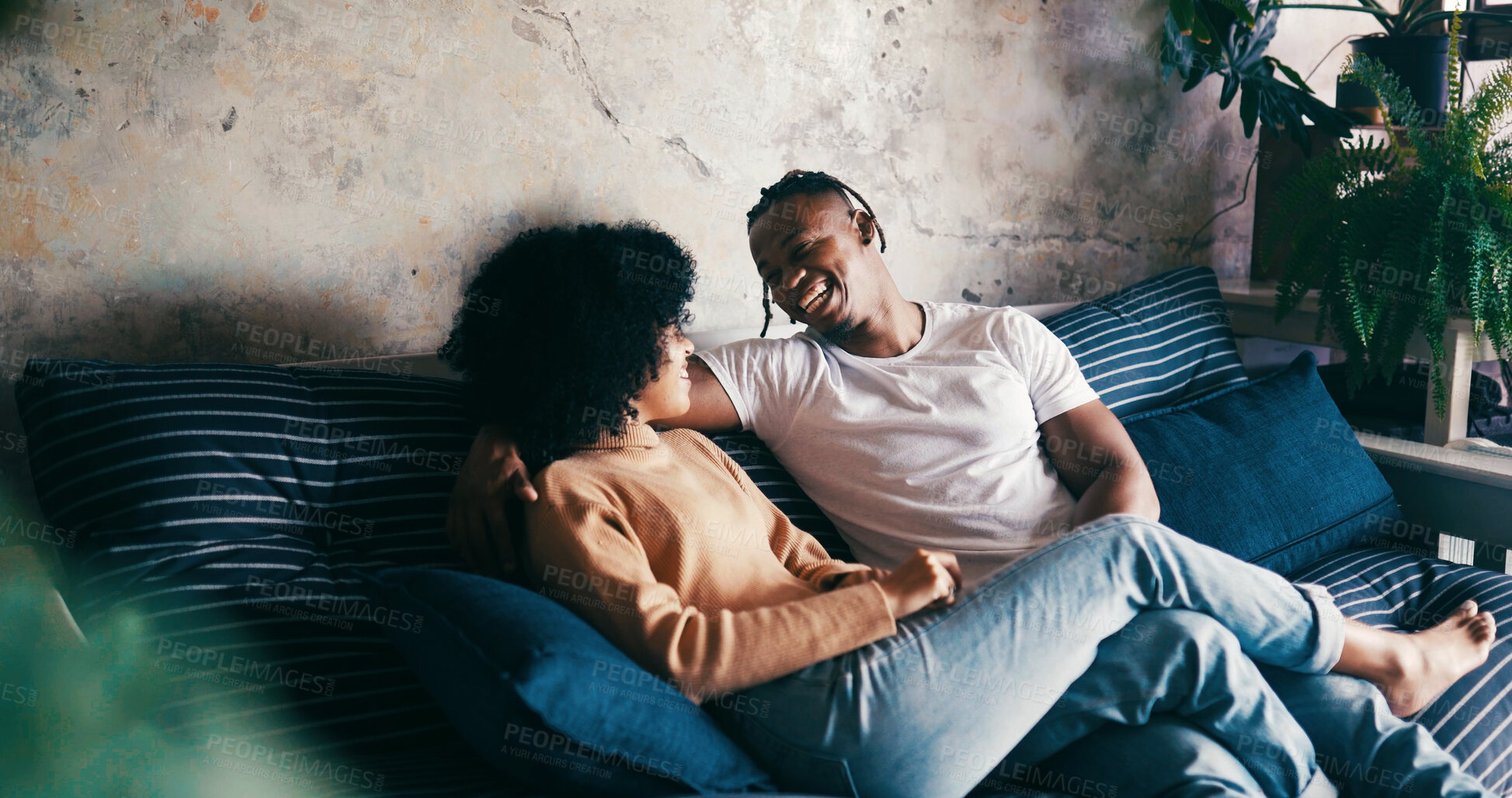 Buy stock photo Home, smile and couple on sofa, love and bonding together with comfort, talking and romance. Laughing, happy man and woman on couch, relax or relationship with discussion, humor or trust with break