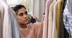 Woman, thinking and checking clothing with rack for choice, option or outfit selection in home. Thoughtful, female person or decision with garment line in room for fashion, style or quality in house