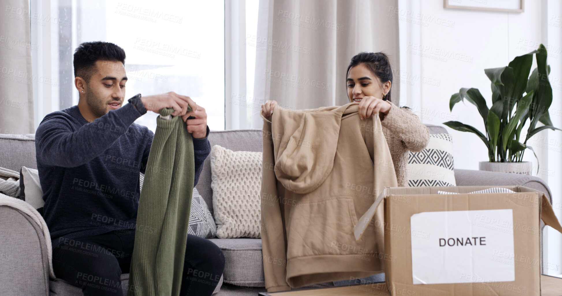 Buy stock photo Couple, folding clothes and donation box in house for charity initiative, nonprofit or declutter home. Married people, apparel or giveaway in package for NGO contribution, support or spring cleaning.