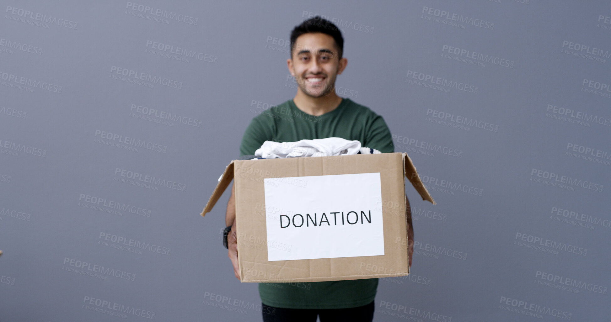 Buy stock photo Happy man, portrait and box with donation in studio for charity or welfare on a gray background. Male person, volunteer or model with package or clothing parcel for community service on mockup space