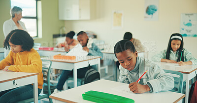 Buy stock photo Boy, writing test and learning in classroom at school, assessment and development with scholarship. Child, education and exam paper with problem solving, answer or pupils with evaluation at academy