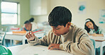 Writing, education and quiz with boy in classroom for test, child development and knowledge. Studying, assessment and academy with student on school campus for learning, course curriculum and exam