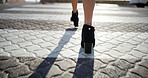 Back, walking and woman in city, high heels and travel with morning commute. Closeup, person and professional in street, shoes or comfort with journey, adventure and trip with location or destination