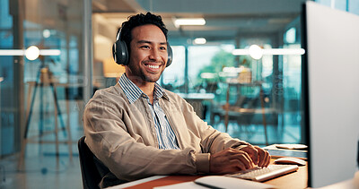 Buy stock photo Headphones, smile and typing with designer man at desk in office for planning or research. Computer, development and music with happy employee in creative workplace for productivity or streaming