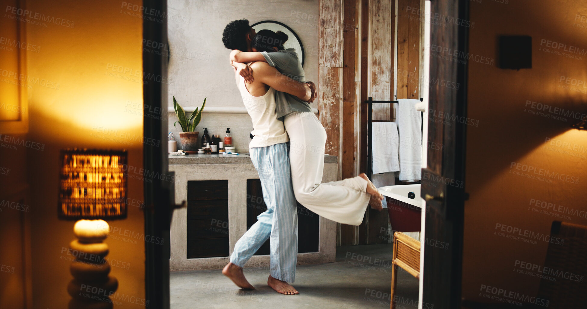 Buy stock photo Love, couple and hug in bathroom for night affection, care  and connection in relationship bonding. Evening embrace, romance or people in home together for commitment, marriage or security in support