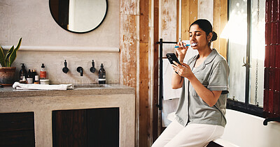 Buy stock photo Brushing teeth, bathroom or woman with phone for grooming routine, multitask or entertainment. Distraction, check email or person with morning self care in home, mobile or timer for dental hygiene