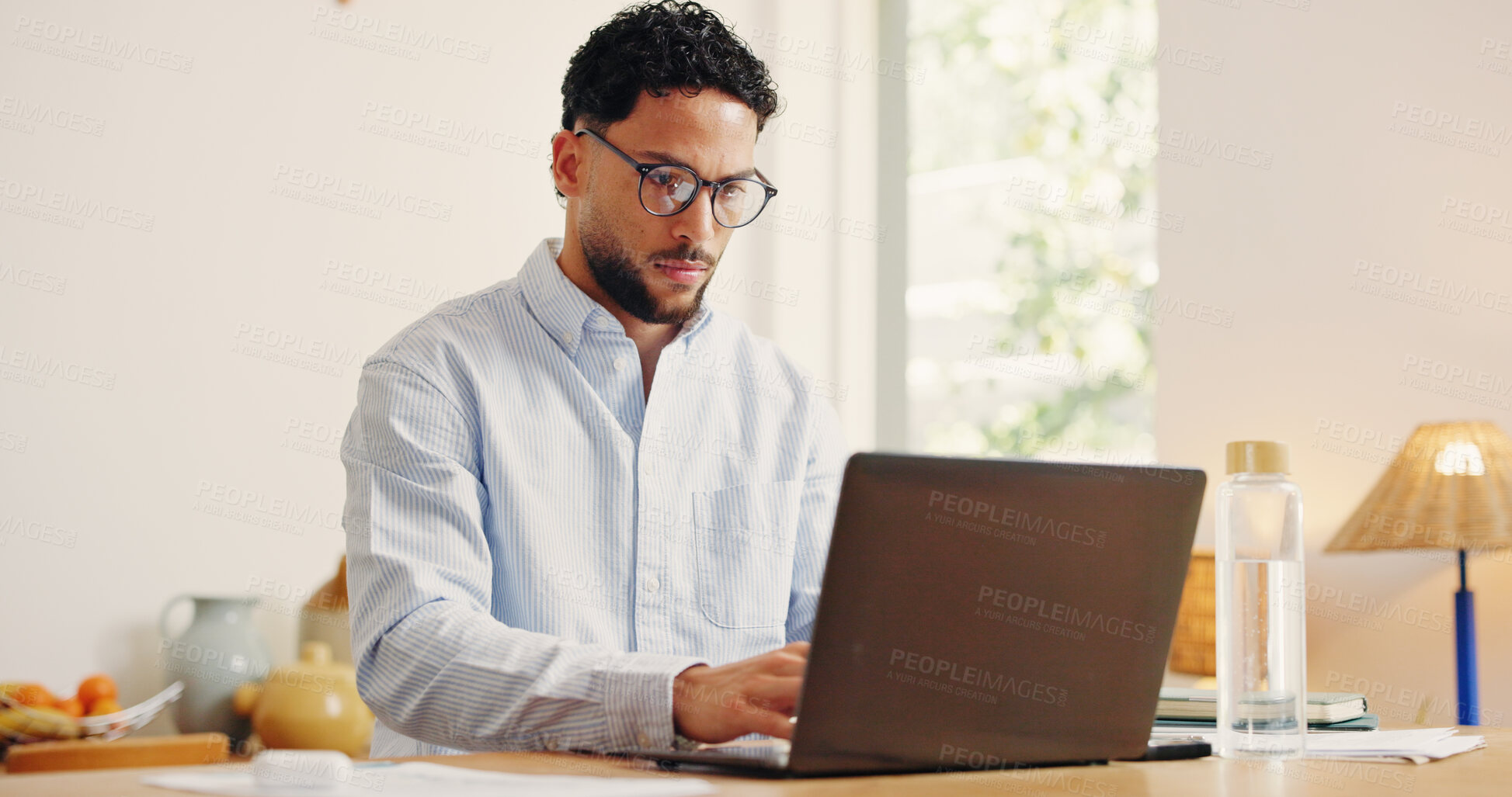 Buy stock photo Laptop, reading and typing with business man in home office for problem solving or research. Computer, glasses and remote work with serious freelancer at desk in apartment for startup planning