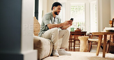 Buy stock photo Man, typing and smile with phone on couch for social media notification, online dating and virtual chat. Happy, person and scroll in home with tech for text message, browsing internet and mobile app.