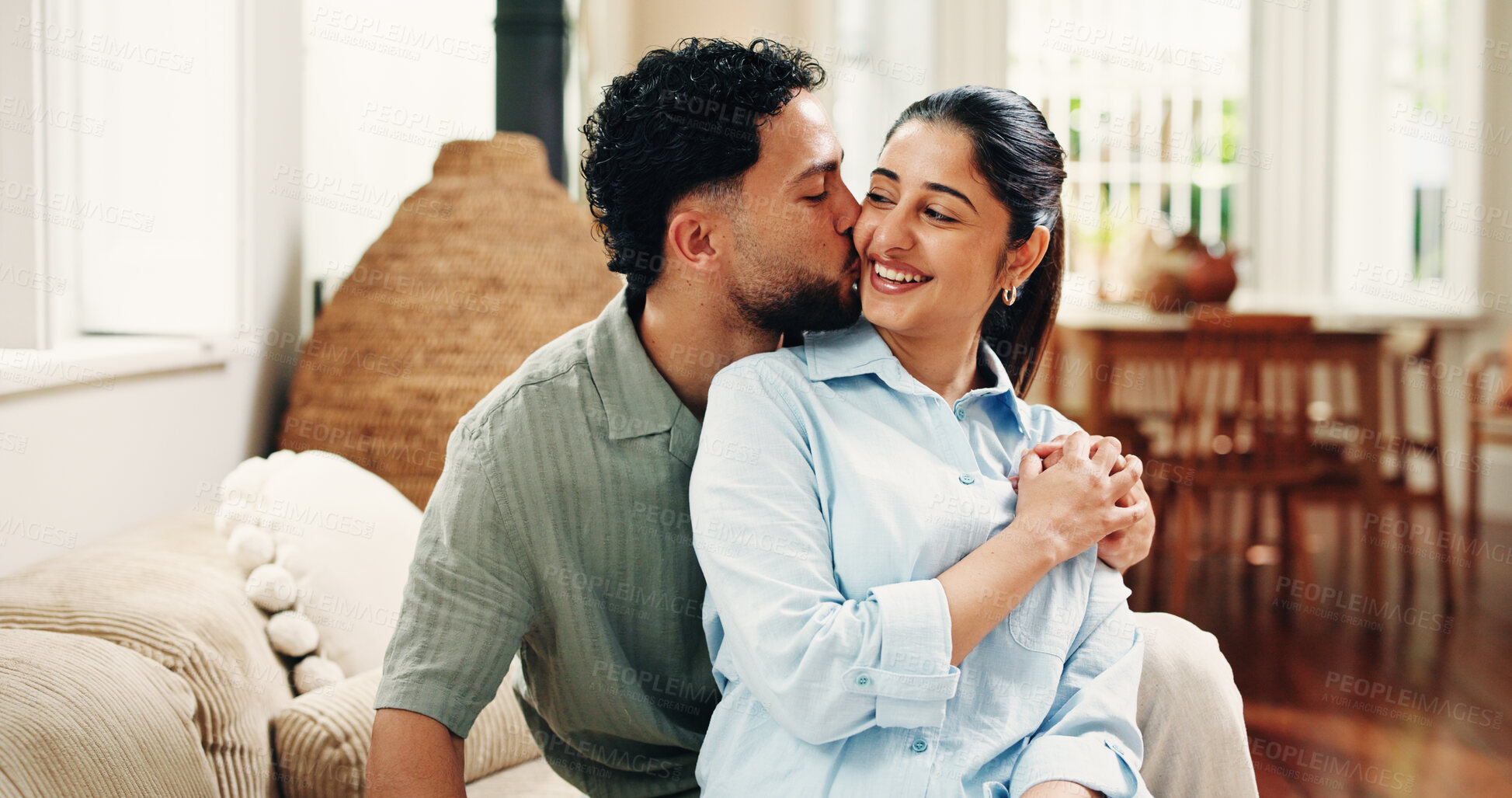Buy stock photo Happy, kiss cheek and couple in home for connection, bonding and relax in apartment. House, marriage and man with woman embrace in living room for commitment, healthy relationship and love on weekend