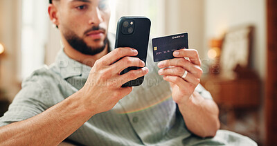 Buy stock photo Credit card, purchase or man on sofa with phone, online banking or payment in eft transaction. Serious, easy transfer or male person at house with tech, remote or debit details for cashless service.
