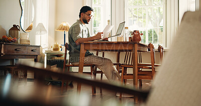 Buy stock photo Reading, paperwork and man with laptop, confused and freelance contract for design project and home. Review, clause and person with documents for remote work, graphic designer and puzzled in house