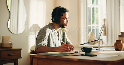 Buy stock photo Laptop, video call and man with headphones, home and notes for logo design, listening and freelance. Creative, graphic designer and person with notebook for virtual meeting, writing and communication