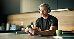 Headphones, streaming or man in home with phone, song connectivity or listening to music playlist. Sound track, mature or male person in kitchen with tech, podcast or radio subscription on audio app.