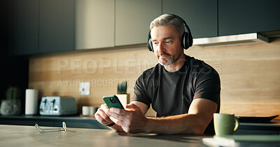 Buy stock photo Headphones, streaming or man in home with phone, song connectivity or listening to music playlist. Sound track, mature or male person in kitchen with tech, podcast or radio subscription on audio app.