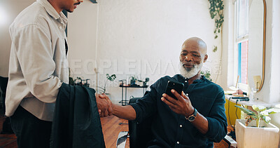Buy stock photo Senior man, barber and handshake with phone for hairstyle, option or choice in beauty salon. Elderly, male person or customer shaking hands with hairdresser on mobile smartphone for haircut service