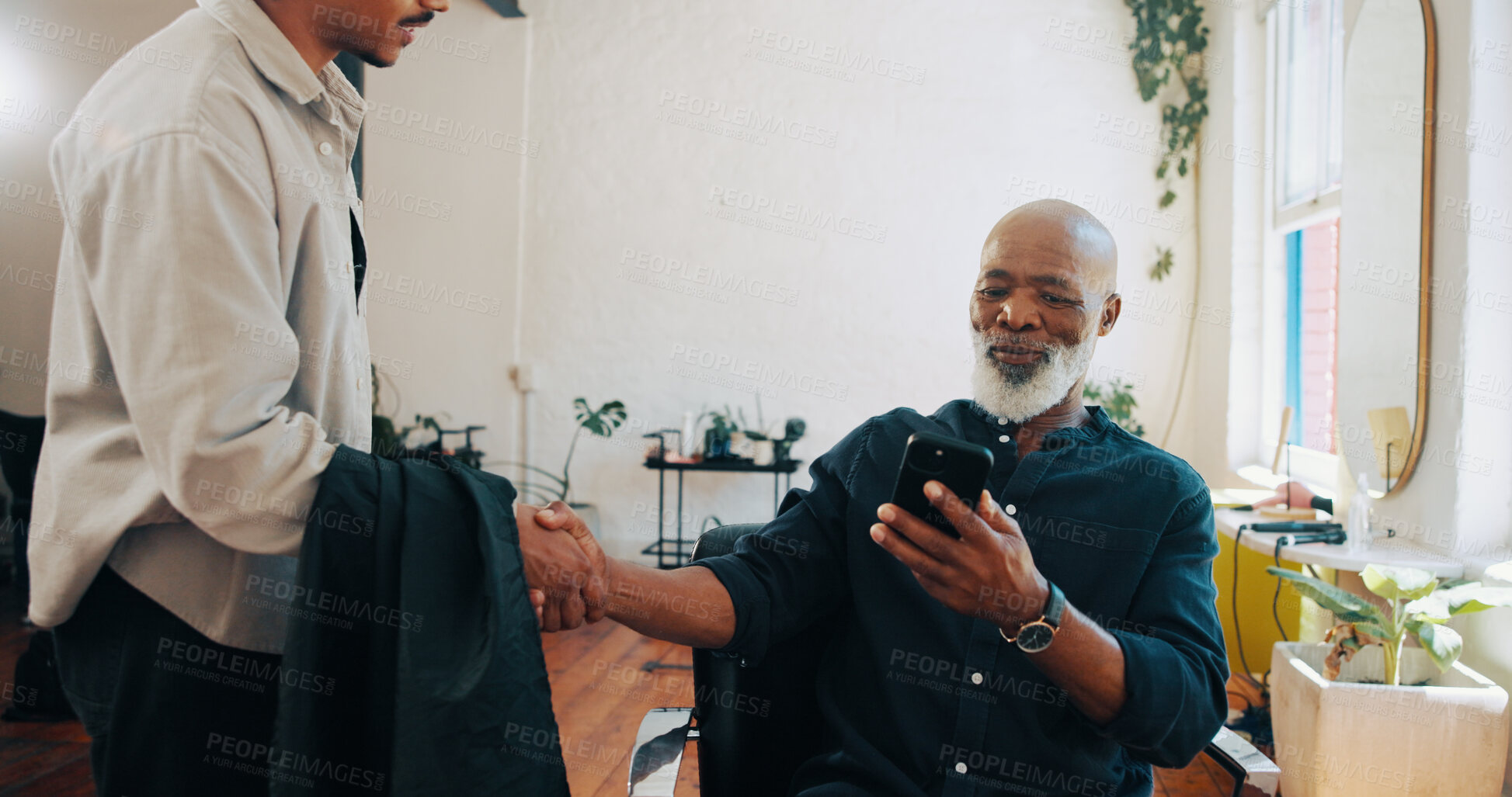 Buy stock photo Senior man, barber and handshake with phone for hairstyle, option or choice in beauty salon. Elderly, male person or customer shaking hands with hairdresser on mobile smartphone for haircut service