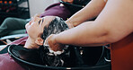 Salon, woman and washing hair in sink with shampoo for maintenance, hygiene or styling appointment. People, hairdresser or clean client scalp in basin with liquid soap, grooming or massage treatment.