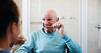 Elderly man, nurse and help for brushing teeth in bathroom, motor skills exercise and dental hygiene in home. Caregiver, wood toothbrush and oral care for senior person with disability in retirement