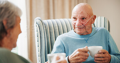Buy stock photo Conversation, couple and tea with senior man on oxygen for break, recovery or retirement. Breathing tubes, drink and relax with old people speaking in apartment for beverage, connection or love