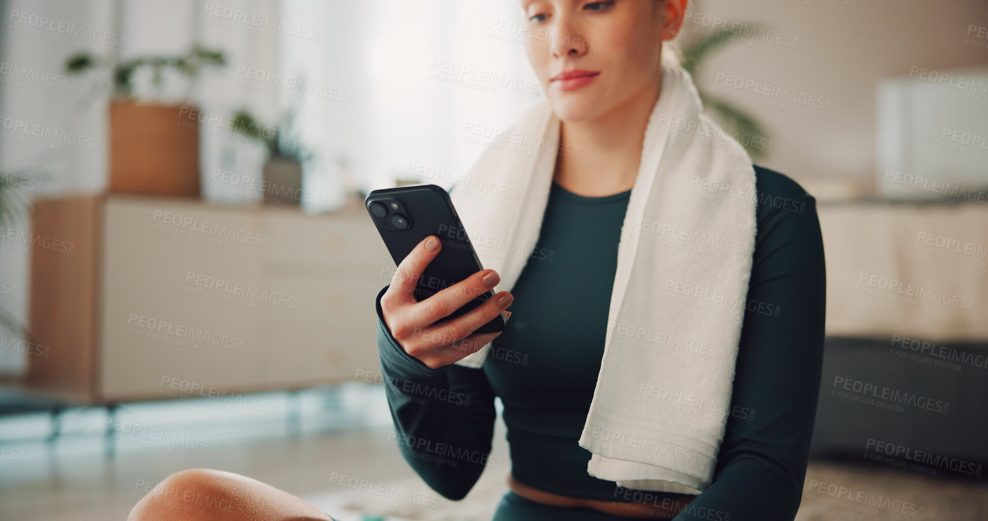 Buy stock photo Hands, phone and texting with exercise in home, break and check notification on fitness app. Woman, smartphone and rest with towel on floor, scroll or tracking progress for training at apartment