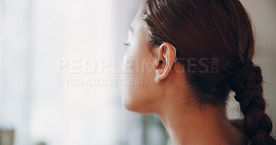 Buy stock photo Thinking, woman and relax with hearing aid at house with ear device, sound and auditory assistance. Space, technology and female person with disability, deaf and audio implant with speech reflection