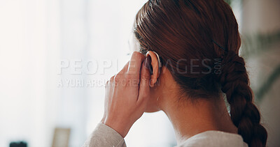 Buy stock photo Hand, woman and touch hearing aid in home with ear device, testing sound and auditory assistance. Back, medical equipment and female person with disability, deaf and audio implant for speech process