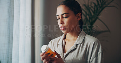 Buy stock photo Reading, woman and pills in home for healthcare, prescription and supplement for treatment. Medicine, check label and person in house with cure, remedy and info with medical product for side effects