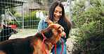 Happy, woman and smile with dog at shelter for adoption service, homeless animal and rescue centre. Love, girl and puppy by fence for bonding, foster care and pet welfare or charity ngo support