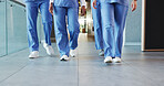 Legs, people and nurses walking in hospital for staff duty, shift change and medical services. Group, employees and team in lobby for patient care, healthcare treatment and ward round for procedure