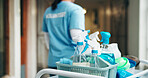 Hands, person and volunteer with supplies for cleaning, corridor maintenance and workplace hygiene. Woman, trolley and equipment for hallway cleanliness, chemical detergent and sanitation of facility