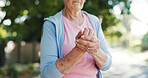 Senior woman, hands and wrist pain with injury in nature for carpal tunnel syndrome in road. Closeup, elderly or female person with sore arm or fibromyalgia for joint inflammation or muscle tension
