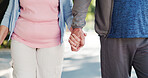 Senior couple, walking and holding hands with commitment for trust, support or outdoor date in road. Elderly, man and woman with love for holiday, weekend or retirement journey in neighborhood
